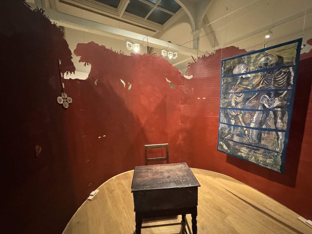 Circular gallery space with wooden desk and chair arrangement